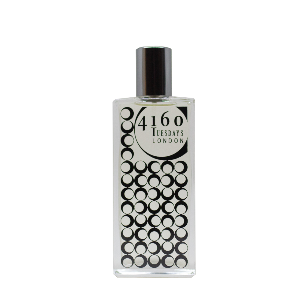 A clear glass perfume bottle with a silver cap. The bottle features a label with "4160Tuesdays" and a pattern of black circles, reminiscent of the delicate dance of damselflies over still waters, named "Butterlily Damselfly.