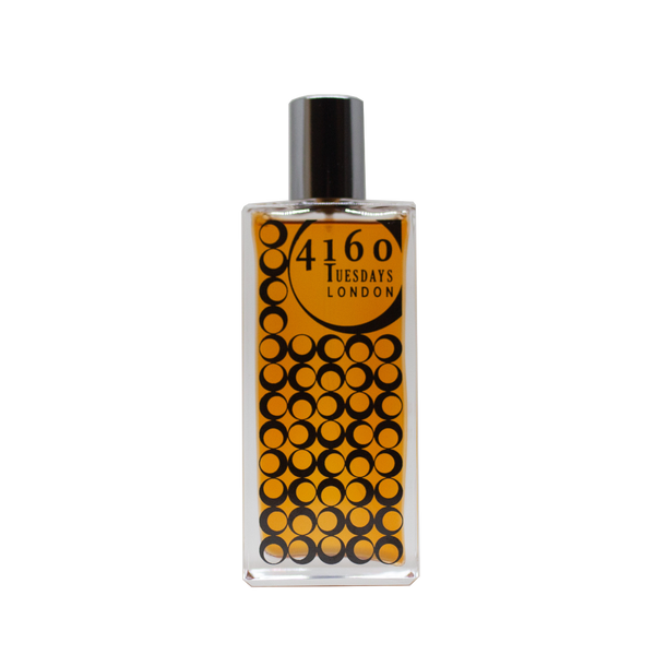A rectangular perfume bottle with a black cap. The label reads "4160Tuesdays" and features a pattern of overlapping black circles on an orange background, hinting at the sultry balsams within.