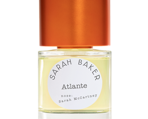 A bottle of Sarah Baker's 'Atlante' perfume, an Art + Olfaction Awards finalist, with a round white label naming Sarah McCartney as the creator. The bottle has an orange cap and exudes a salty fragrance.