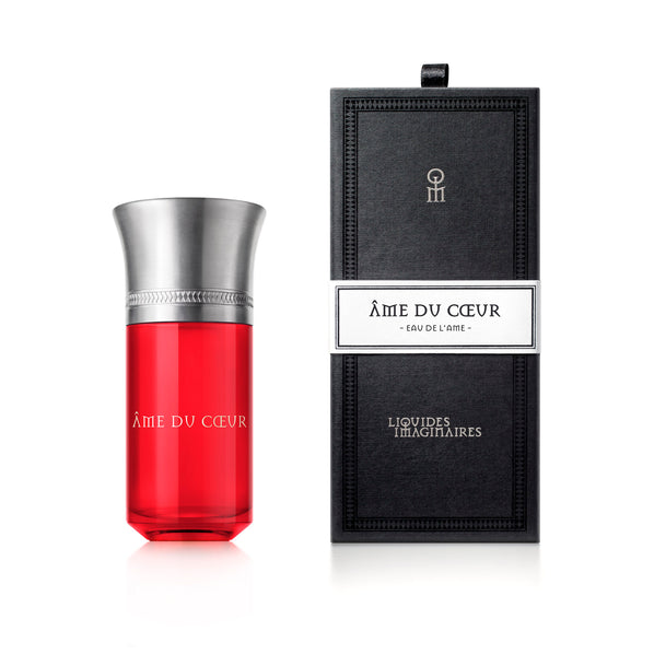 A red perfume bottle labeled "Ame Du Coeur" stands next to a black rectangular box with white labeling, both from the Liquides Imaginaires collection, perfectly capturing the essence of love and emotions.