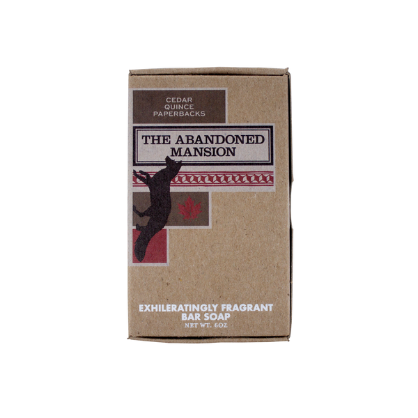 A brown cardboard box of bar soap labeled "Abandoned Mansion Soap" by Imaginary Authors with a scent description of cedar, quince, and paperbacks. Infused with shea butter, this exhilaratingly fragrant bar soap (NWT 6oz) captures the essence of an abandoned mansion in the Adirondacks.