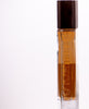 A rectangular glass perfume bottle with a wooden cap is filled with amber-colored liquid. The word "Perfumology" is embossed vertically on the side, showcasing their dedication to high quality ingredients. The background is plain white. The product name "Blyss" enhances the allure of this exquisite fragrance.