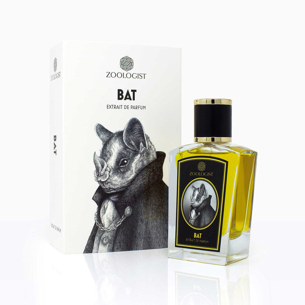 A perfume bottle labeled "Zoologist Bat" is displayed next to its matching box, which features an illustration of a bat in a suit. This fruity tropical perfume evokes the essence of a bat's cavernous home, blending mystery with vibrant, exotic notes.