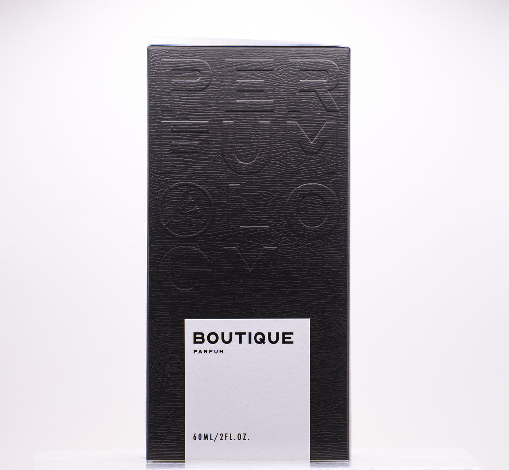 A black perfume box with the words "Perfumology Boutique" in white text holds 60ml (2 fl. oz.) of a luxurious fragrance, blending fruity floral notes with woody white musk for an enchanting aroma.