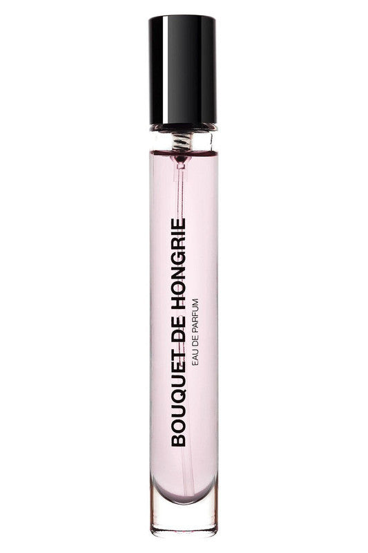 Clear bottle with black cap labeled "Bouquet de Hongrie Eau de Parfum by BDK Parfums," containing light pink liquid, perfect for a sunny day on the balcony in a light dress.