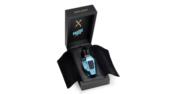 A Groove Xcape fragrance bottle by Xerjoff, designed in blue and crafted with precious ingredients, is displayed in an open black box adorned with gold text.
