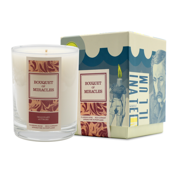 A white candle in a glass container labeled "Bouquet of Miracles" is placed next to its decorative box. The box features artistic illustrations and the text "Imaginary Authors" from Portland, Oregon. The scent features notes of Rose Red Currant, adding a touch of elegance.