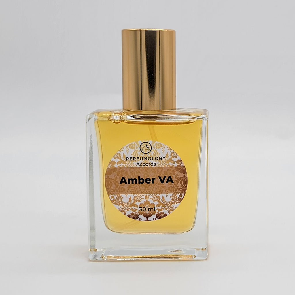 A square glass bottle with a gold cap, labeled "Amber VA" and "Perfumology Accords 30 mL." The label, designed by Vincent Avery, includes decorative designs. Inside, the bottle holds a yellowish liquid.