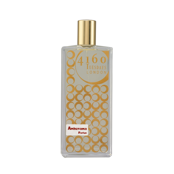 A rectangular perfume bottle with a gold cap labeled "4160Tuesdays" and "Amberama." The bottle features a pattern of gold circles on the front, hinting at notes of raspberry and sandalwood.
