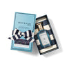 Bottle of Shay and Blue fragrance presented in a rectangular blue box with a striped ribbon. The box is labeled "Black Tulip," an oriental floral scent with hints of white chocolate.