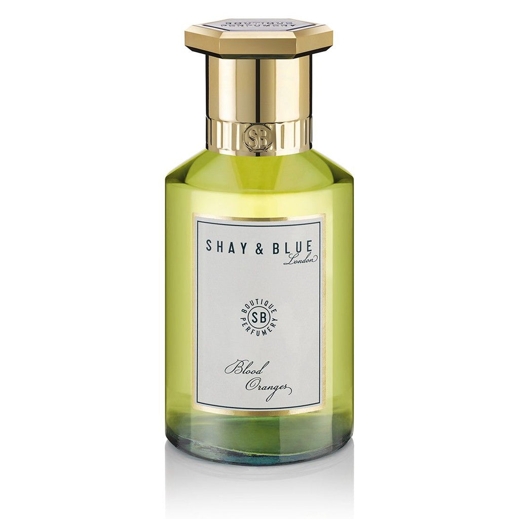 A bottle of Shay and Blue Blood Oranges fragrance, unisex with a gold cap and a white label. This vegan scent captures the essence of fresh citrus in an elegant presentation.