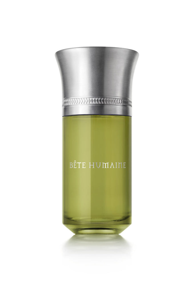 A green glass bottle labeled "Bete Humaine" by Liquides Imaginaires with a silver metal cap, exuding a forest scent reminiscent of chestnut trees.