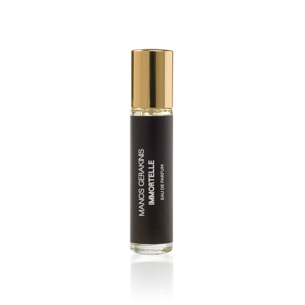 A small glass perfume bottle with a black label and gold cap. The label reads "Manos Gerakinis Immortelle," capturing the essence of Greek heritage in every drop of this exquisite fragrance.
