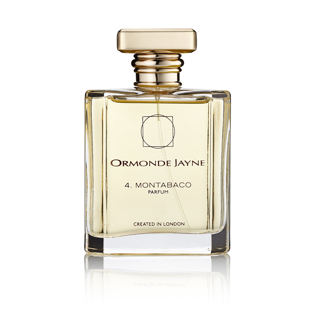 A clear glass bottle with a metallic gold cap, containing Ormonde Jayne's Montabaco perfume. This seductive fragrance carries a Latin American essence. The label states "Created in London" by Ormonde Jayne.