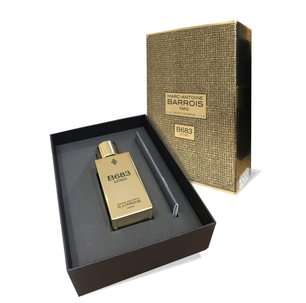 A luxury perfume bottle labeled "B683 Extrait" by Marc-Antoine Barrois, showcased in an open black and gold box alongside its matching lid section, exudes a captivating woody-leathery accord.