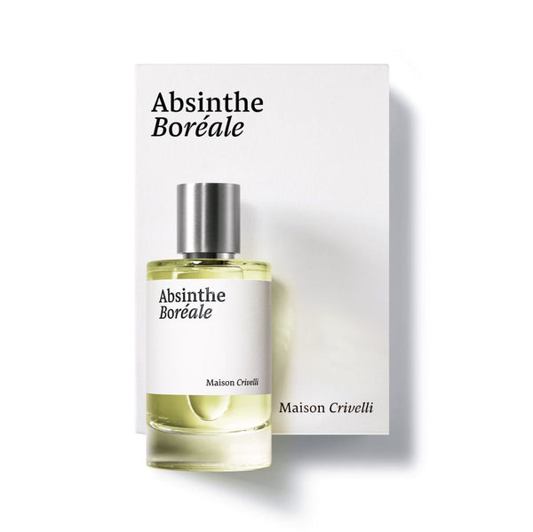 A bottle of Absinthe Boréale by Maison Crivelli is placed in front of its box, which features the same minimalistic design and text. The bottle emanates an aromatic musky scent that captures the essence of its essential oil ingredients.