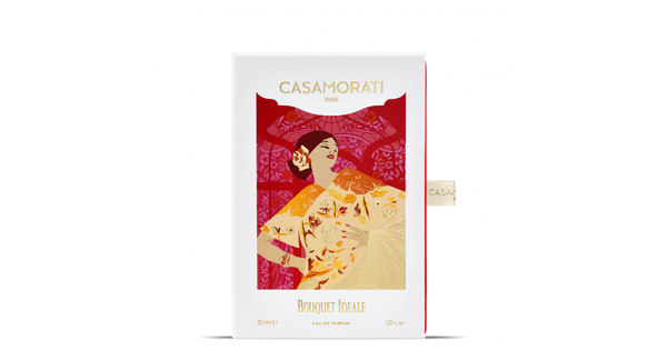 A bottle of Bouquet Ideale by Casamorati, 30 ml, with a stylized design of a woman in traditional attire and floral patterns on the packaging, captures the essence of Italian perfumery while exuding a vintage scent.