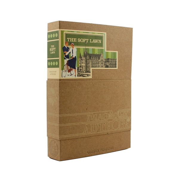 A perfume box labeled "The Soft Lawn" by Imaginary Authors features an illustration of two people on a bicycle with buildings in the background. The scent, enriched with notes of linden blossom and vetiver, is unisex. The bottom of the box states, "Unisex Perfume.