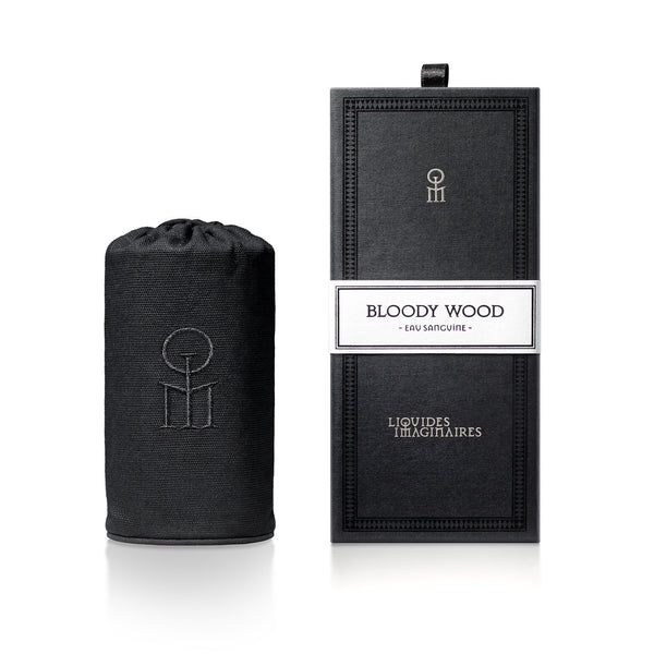 A black cylindrical container and a black rectangular box with "Bloody Wood, Eau Sanguine, Liquides Imaginaires" labeled on the front, featuring a mesmerizing perfume crafted by Shyamala Maisondieu.