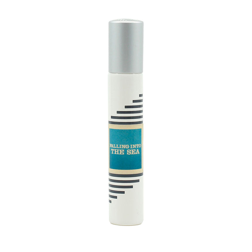 A small white perfume bottle with a silver cap and a label that reads "Falling Into the Sea." The label, designed by Josh Meyer, has black and blue stripes around the text, hinting at the summer scent within—an invigorating blend of lemon nuances. This delightful fragrance is brought to you by Imaginary Authors.