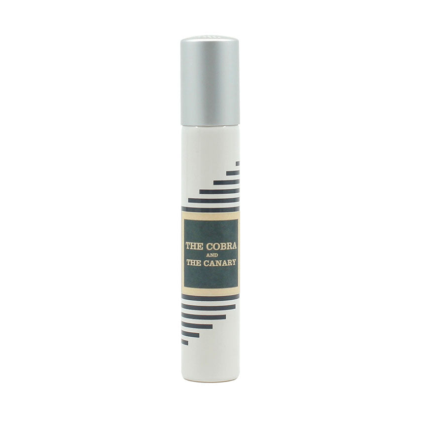 A white cylindrical spray bottle with a silver cap, labeled "The Cobra & The Canary" by Imaginary Authors. The design features black diagonal lines and a yellow accent, evoking the decadence and desolation of Palm Springs race tracks.