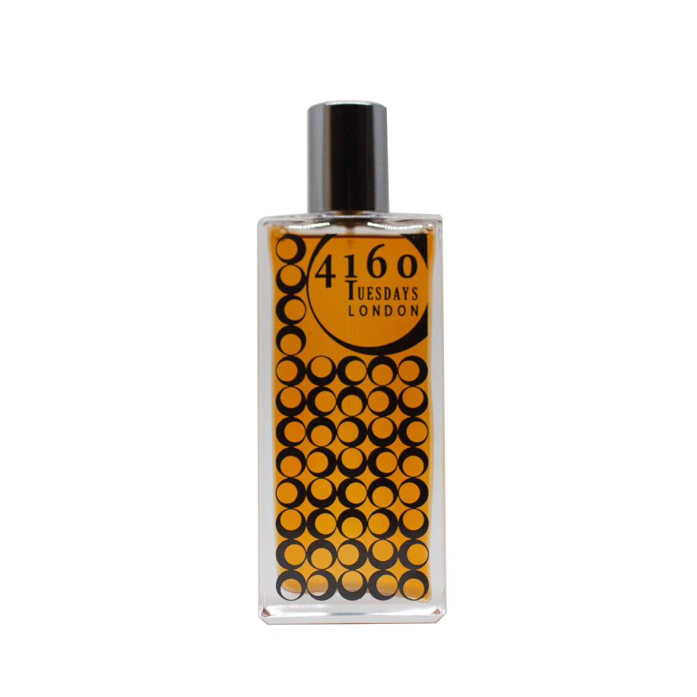 A rectangular perfume bottle with a black cap. The label reads "4160Tuesdays" and features a pattern of overlapping black circles on an orange background, hinting at the sultry balsams within.