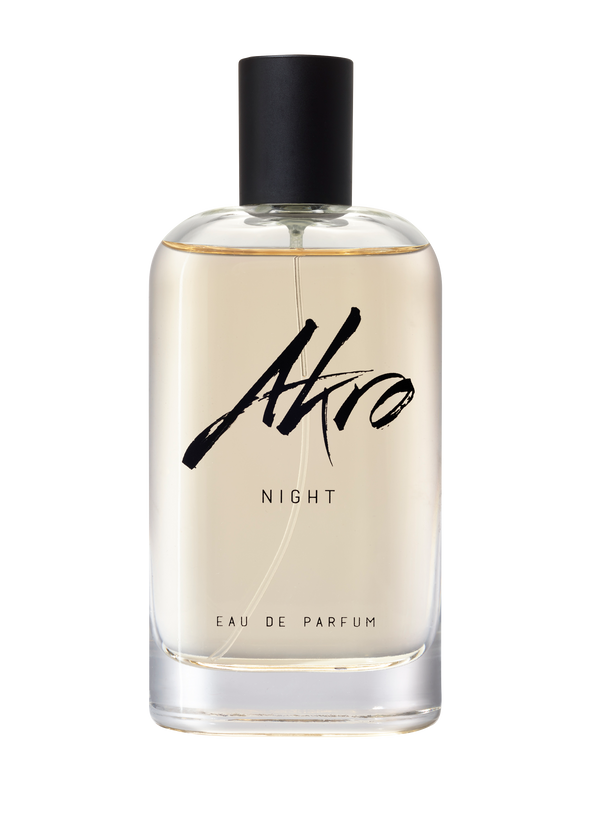 A clear bottle with a black cap labeled "Akro NIGHT Eau De Parfum." The light yellow liquid inside features musky notes.