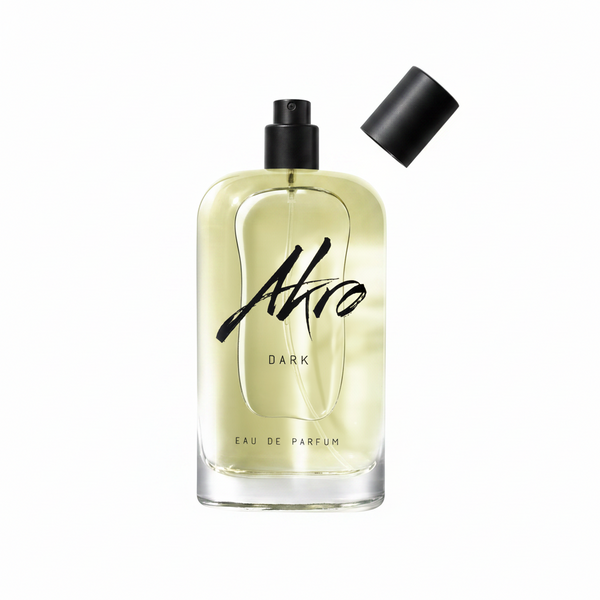 A clear glass bottle of Akro DARK Eau de Parfum with a black spray top and detachable cap, exuding mature sensuality with its addictive chocolate fragrance.