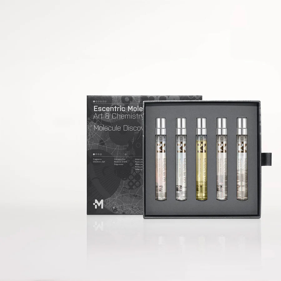 A set of five slim, cylindrical perfume vials in a black box with a chemistry-themed design. The box is partially opened, revealing the vials housed in a foam insert, inviting you to explore the Molecule 8.5ml Discovery Set by Escentric Molecules and ignite your olfactory creativity.