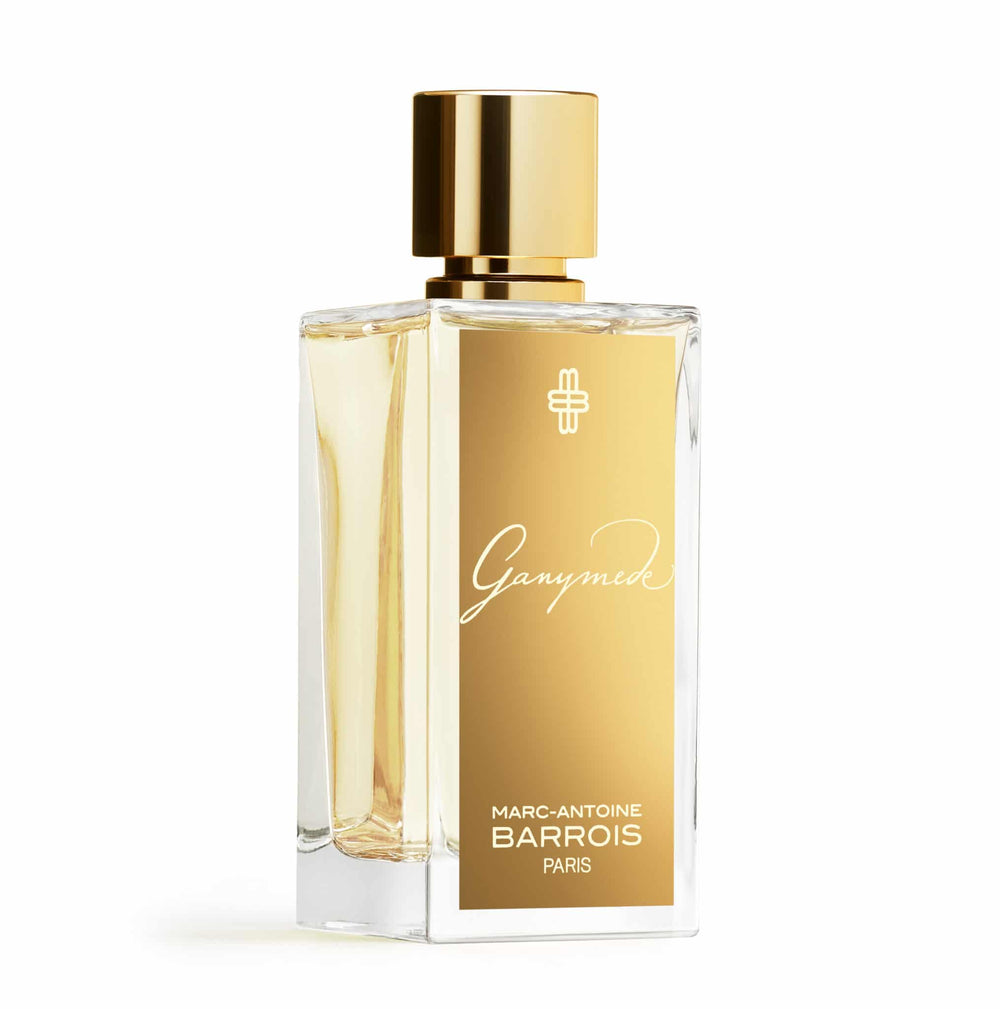 Clear glass bottle of Marc-Antoine Barrois Ganymede perfume, filled with light yellow liquid and featuring a gold label and cap.