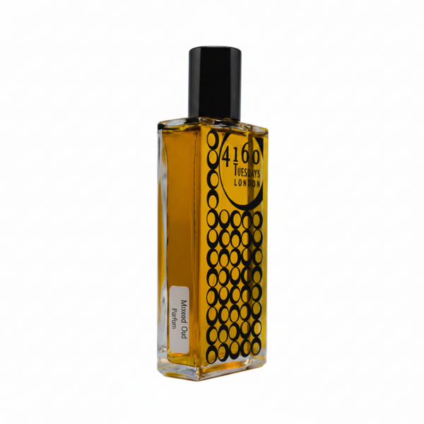 A rectangular perfume bottle with a black cap and geometric circle design emanates an intense scent. The label on the bottle reads "Maxed Out" by 4160Tuesdays, evoking memories of a wild night out fragrance from New York 2003.