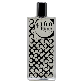 A clear rectangular perfume bottle labeled "4160Tuesdays Freshly Laundered" with a black circles pattern on the front, reminiscent of clean laundry swaying in a summer breeze.