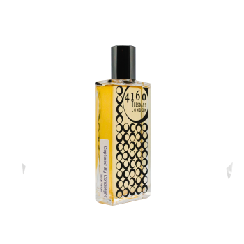 A rectangular perfume bottle with a black cap, labeled "4160Tuesdays" and "Captured by Candlelight." The bottle is adorned with a pattern of black circles, evoking its rich, fruity boozy fragrance that blends oriental gourmand notes.