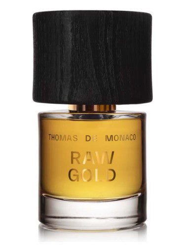 A bottle of alluring perfume labeled "Raw Gold Extrait de Parfum" by Thomas De Monaco, featuring a dark wooden cap and amber liquid inside, exuding an aura of eternal youth.
