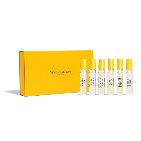 A yellow box labeled "Vilhelm Parfumerie" contains seven small spray bottles of sought-after scents, each with a yellow cap and different names like "Dear Polly" on the bottles.