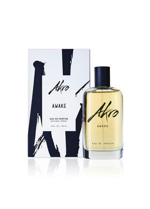 Bottle of Akro's AWAKE Eau de Parfum, 100ml, next to its packaging. The box and bottle feature a black and white design with the word "AWAKE" prominently displayed. This unisex perfume encapsulates the bold essence of a coffee fragrance.