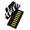 A black box labeled "AKRO 9 x 2ml Discovery Kit" from the brand Akro contains nine small, transparent vials of yellow liquid, each a testament to addictive excess, meticulously arranged in a black foam insert.