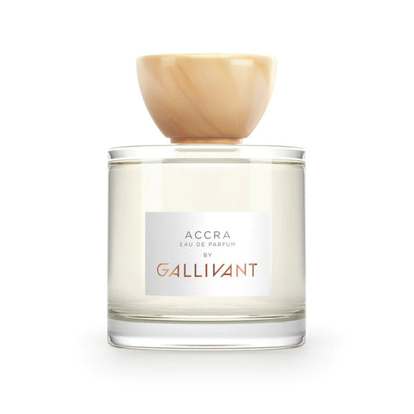 A clear glass bottle of Gallivant Perfumes Accra Eau de Parfum labeled "ACCRA," with a rounded beige cap that hints at tropical mango and papaya.