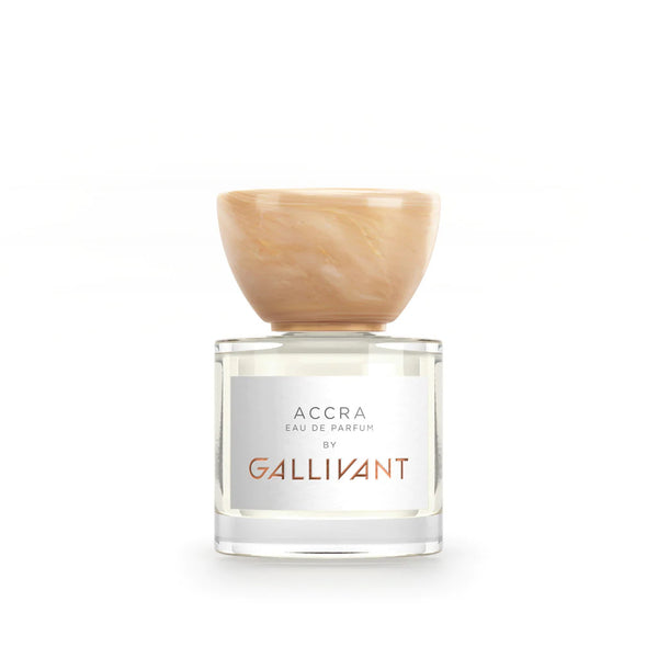 A bottle of Gallivant Perfumes' Accra, featuring a clear container and a tan marbled cap, placed against a white background. This fragrance encapsulates an exotic blend of tropical mango and papaya.