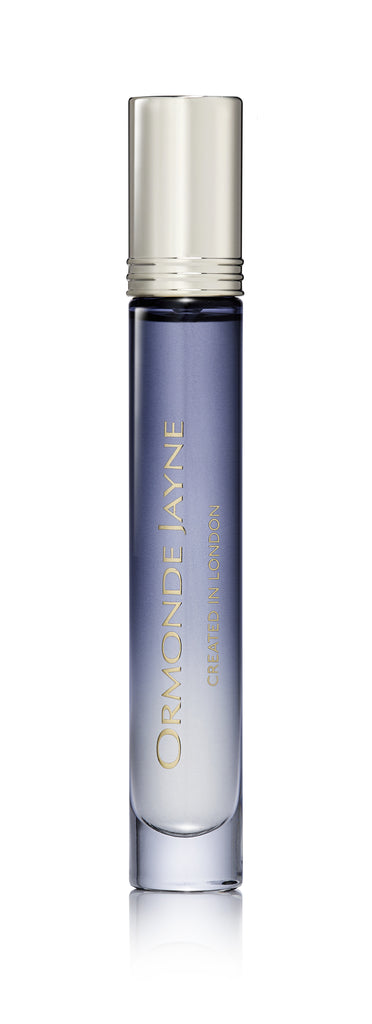 A tall, cylindrical perfume bottle with a silver cap, filled with a gradient blue liquid. The label reads "Ormonde Jayne." This Ormonde Jayne Arabesque perfume features delicate notes of rose and jasmine.
