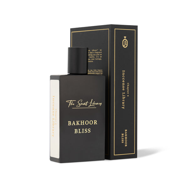 A black perfume bottle labeled "Bakhoor Bliss" stands next to its matching black and gold box, which is upright. The box also features the text "The Scent Library" and "Bakhoor Bliss," promising a scent that evokes spiritual tranquility.
