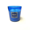 A blue glass Basilica Candle by Milano Fragranze, featuring black and gold details on the label, made from vegetable wax and incense-infused for a captivating aroma.