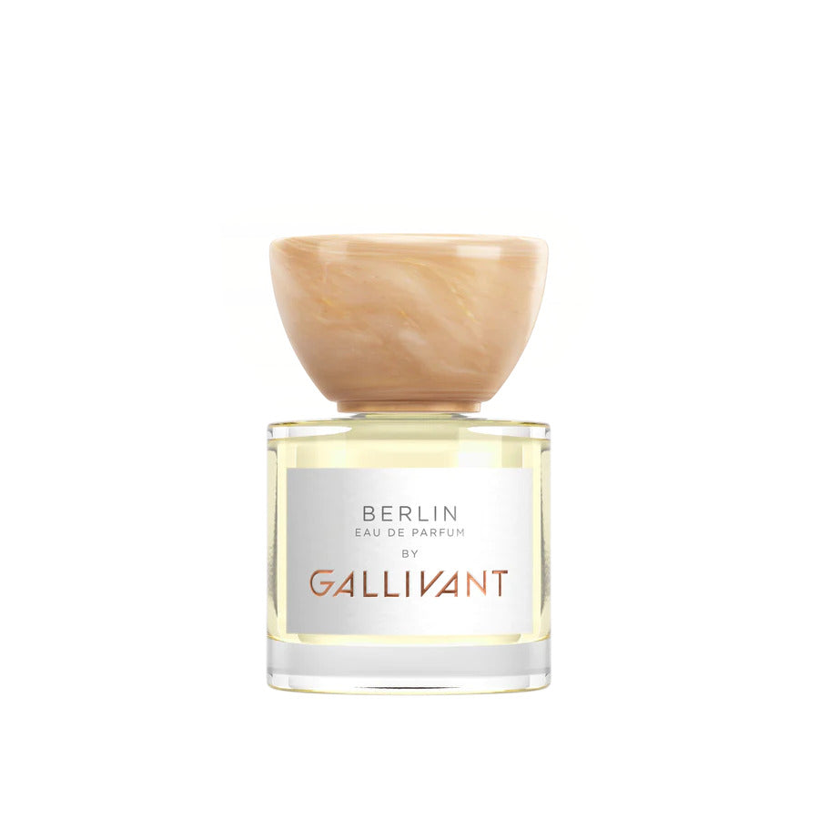 A clear bottle of Berlin by Gallivant by Gallivant Perfumes with a wooden cap, filled with light yellow liquid, boasts a Berlin-inspired fragrance that blends woody citrus spicy notes.