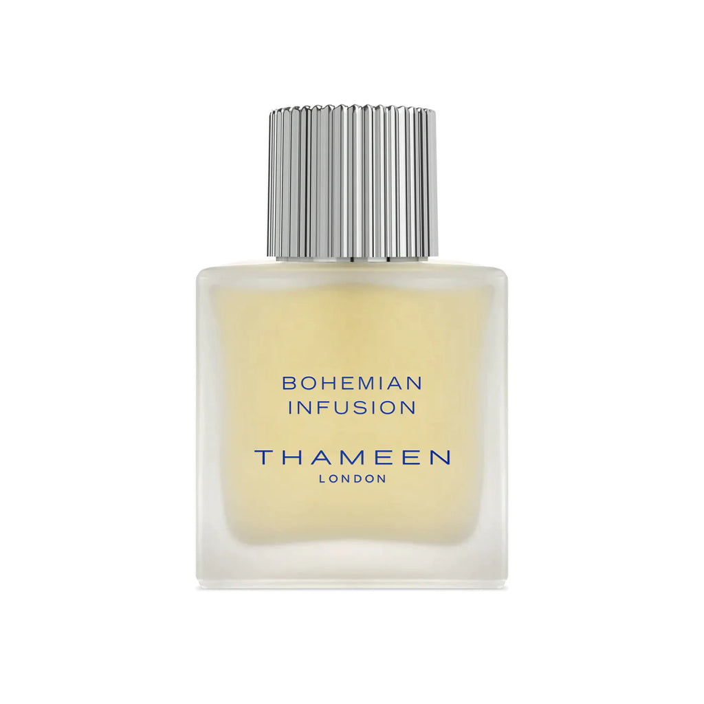 A square glass bottle with a silver cap labeled "Bohemian Infusion THAMEEN" containing a light yellow liquid. Crafted by the renowned perfumer Maurice Roucel, this fragrance contrasts delicate and bold notes, creating an alluring scent experience.
