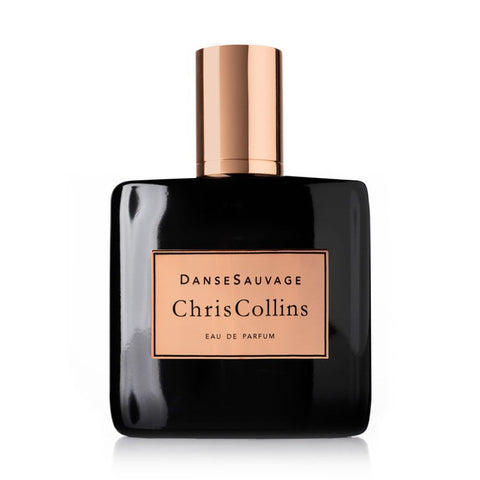 A black perfume bottle with a gold cap, labeled "Danse Sauvage by Chris Collins," offers an enticingly sensual scent with tantalizing oriental notes.
