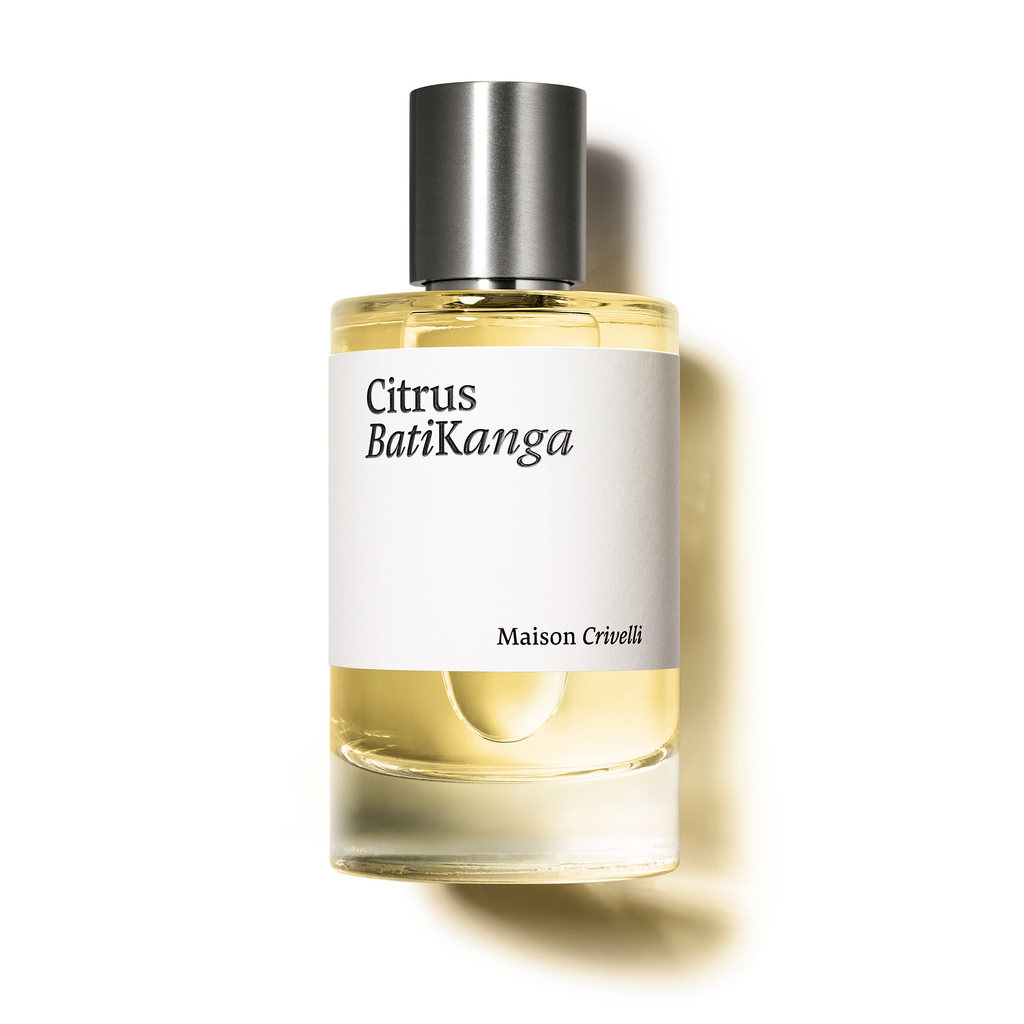 A perfume bottle labeled "Citrus Batikanga" by Maison Crivelli, featuring a clear liquid and a silver cap, is positioned against a white background, exuding an aura of citrus spicy woody notes with hints of bergamot essential oil.