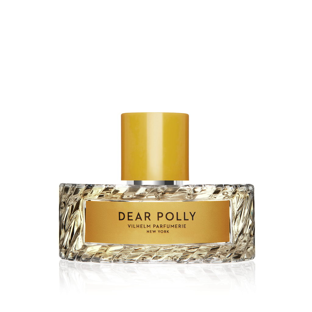 A clear glass perfume bottle labeled "Dear Polly" from Vilhelm Parfumerie New York, featuring a yellow cap and gold accents, with notes of Ceylon black tea.