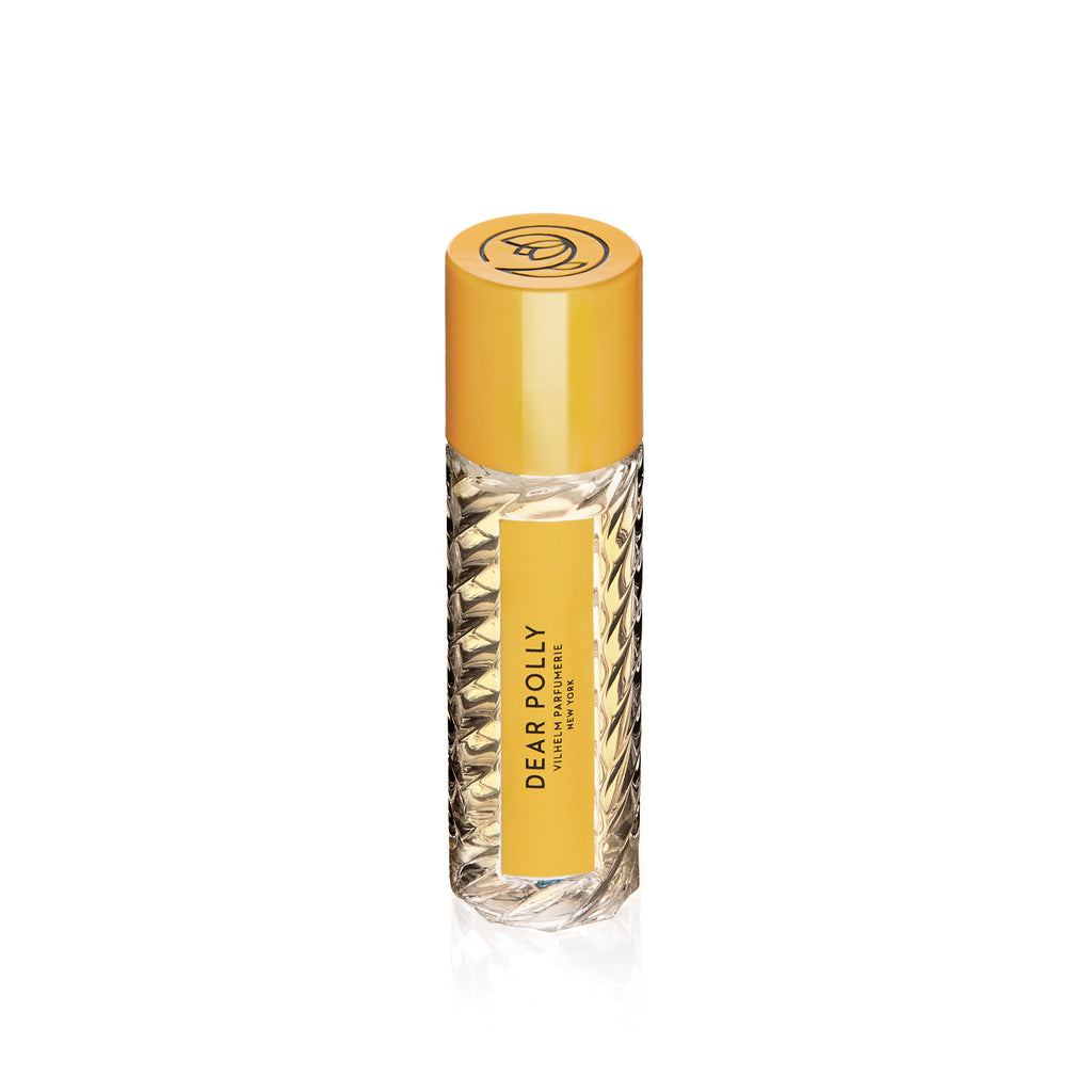 A clear, textured glass bottle of Vilhelm Parfumerie's "Dear Polly" perfume featuring a yellow label and a matching yellow cap, exuding notes of Ceylon black tea.