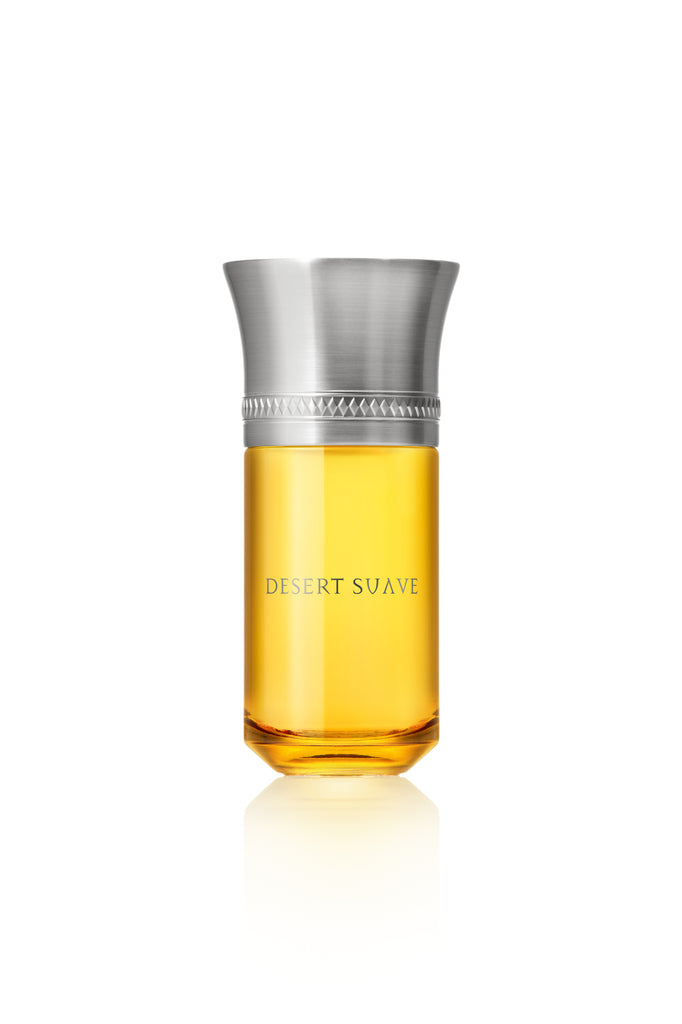 A transparent bottle filled with golden liquid, labeled "Desert Suave" by Liquides Imaginaires, adorned with a metallic silver cap and decorative band, evokes the subtle aroma of orange blossom.