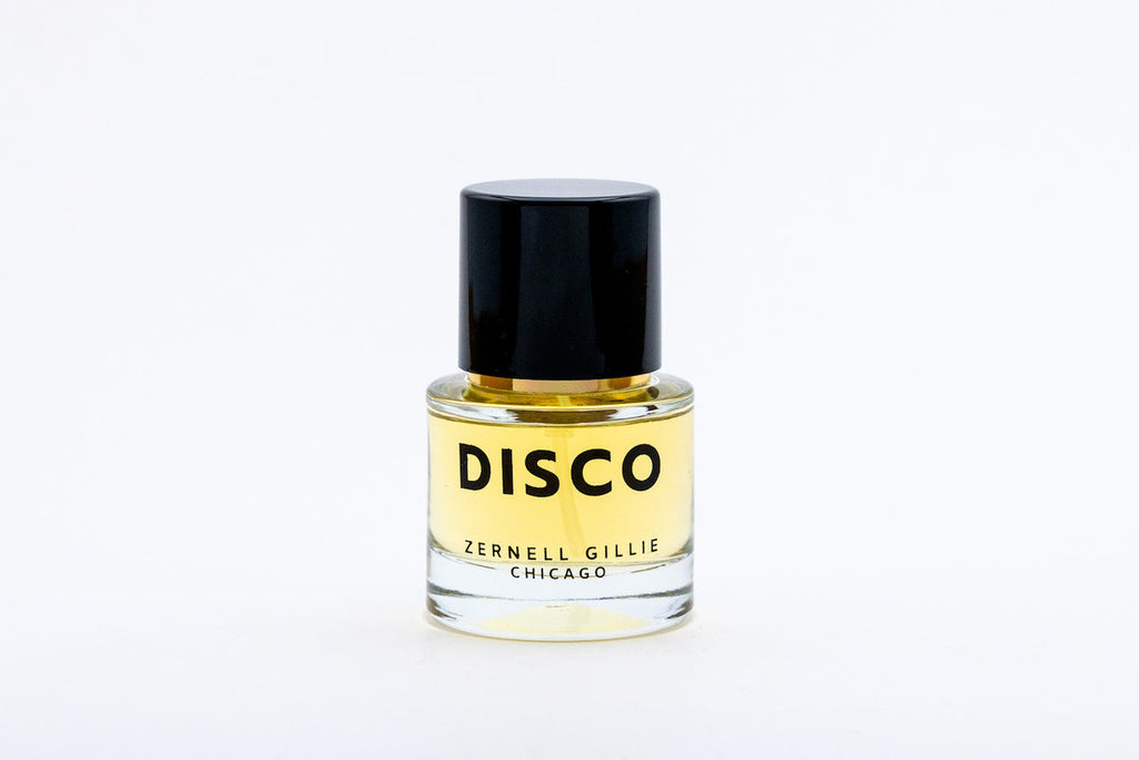A small transparent bottle with yellow liquid, labeled "DISCO" and "Zernell Gillie," features a black cap. This unisex fragrance boasts notes of bergamot, capturing the essence of a signature scent.